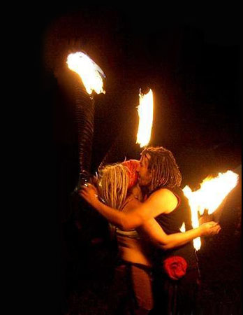 a fire performance picture two fire dancers hugging within the flames